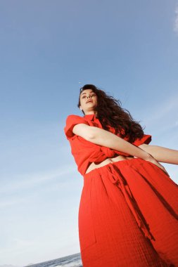 Yaz Rüzgarını Kucaklamak: Güneşli bir sahilde Dans Eden Neşeli Bir Kadın