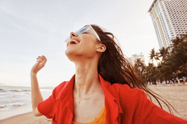 Renkli Sahilde Gülümseyen Kadın: Güneşli Tatilde Özgürlük ve Neşe