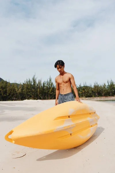 热带逃亡 一个快乐的亚洲人在暑假期间在海滩上划船 — 图库照片