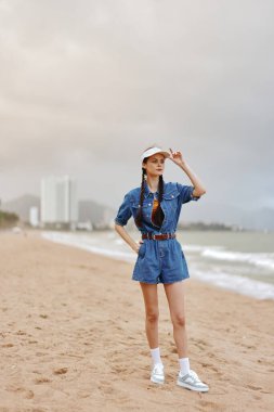 Huzurlu Yaz Kaçamağı: Beyaz Elbiseli Genç, Çekici Bir Kadın Gün Batımında Yalnız Bir Plajda Dinleniyor, Doğanın Huzurlu Güzelliğinin tadını çıkarıyor