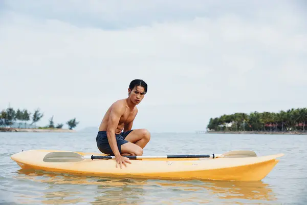 サマーアドベンチャー 熱帯ビーチでカヤックアジア人男性 — ストック写真