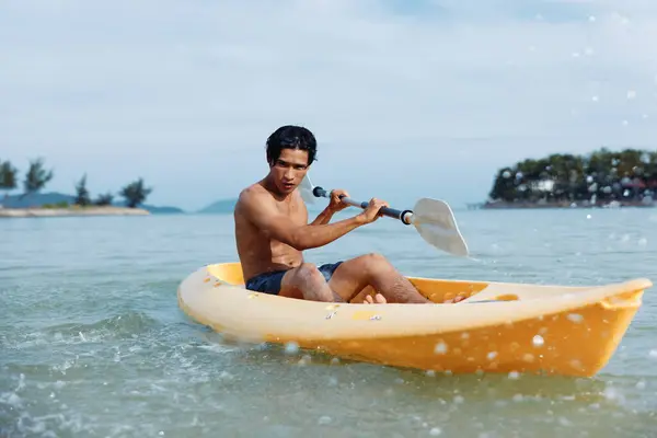 熱帯ビーチでカヤックアドベンチャーを楽しむアクティブなアジア人男性 — ストック写真