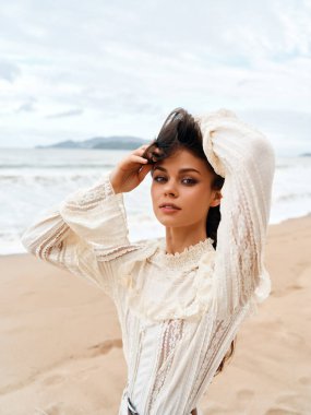 Yaz Güzeli: Esmer Saçlı Çekici Genç Bayan Güneşli Sahilde Açık Havanın Tadını Çıkartıyor, Deniz ve Mavi Gökyüzü Göz kamaştırıcı Arkaplan Olarak