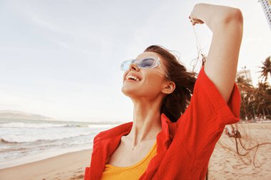 Sahilde Gülümseyen Kadın, Renkli Günbatımında Özgürlük ve Neşeyi Kucaklıyor