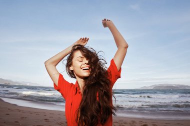 Kırmızı Sahilde Gülümseyen Kadın, Yazın Özgürlüğünün ve Keyifli Tatilinin Tadını Çıkartıyor