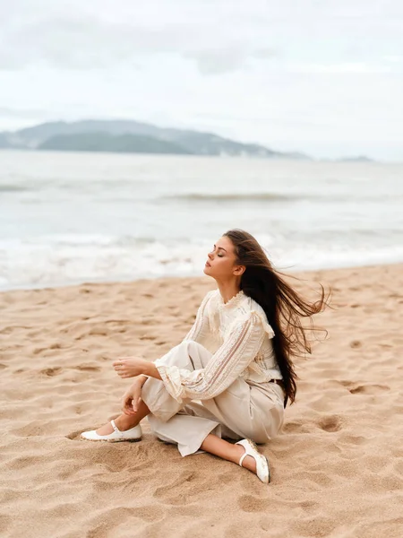 Beautiful Young Woman Enjoying a Relaxing Summer Vacation at the Beach, Admiring the Majestic Ocean and Feeling the Blissful Serenity of Nature