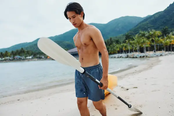 トロピカルビーチパラダイスでハッピーアジアの男カヤック — ストック写真