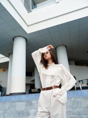 Funky Youth: Kentsel Wall Street 'te kıvırcık saçlı ve şık giyinen güzel beyaz kadın pozu