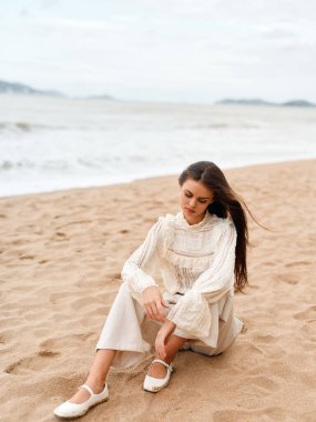 Huzurlu Güzel: Turkuaz Mavi Okyanusu kıyısındaki Muhteşem Beyaz Kumsal Sahili 'nde Rahatlayan Genç Bir Kadın Modeli