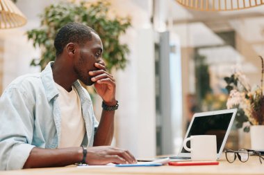 Yaşam tarzı kablosuz iletişim teknolojisi oturan genç iş adamı dizüstü bilgisayarda çalışan erkek iş adamı bilgisayardan akıllı telefondan konuşuyor.