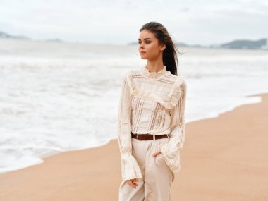 Yaz Rüzgarındaki Güzellik: Çekici Genç Bir Kadın Denizle Rahatlatıcı Sahil Tatilinin Zevkini Çıkartıyor