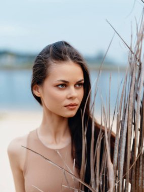 Doğadaki Güzellik: Genç Çekici Beyaz Kadın Modeli 'nin Kapalı Çekici Portresi Sahilde Güzel Saç Pozu Veren, Deniz Tarafından Şehvetli ve Rahatlamış Görünen