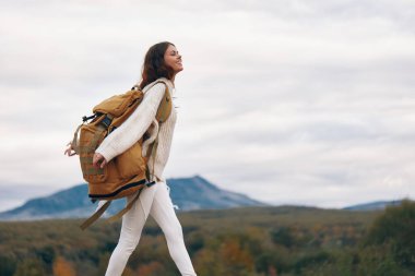 Dağ Macerası: Gülümseyen Kadın Uçurumda Sırt Sırtında, Doğanın ve Özgürlüğün Tadını Çıkartıyor