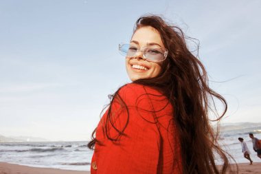 Deniz kenarındaki Gülümseyen Kadın: Renkli Özgürlük ve Neşe Portresi