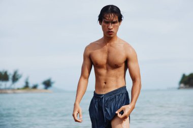 Tatilde Yüzen Adam: Tropikal Plajın, Kristal Açık Mavi Okyanusun ve Güneşte Eğlencenin tadını çıkaran