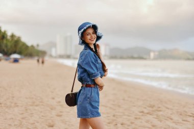 Yaz Tatili Güzelliği: Çekici Genç Kadın Modeli Beyaz Kum Sahili 'nde Dinleniyor, Okyanus ve Gökyüzü ile Mutlu ve Özgür Görünüyor.