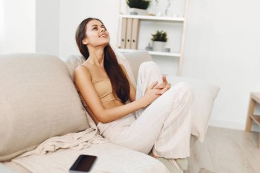 Ev Mutluluğu: Modern Oturma Odasında Beyaz Koltukta Gülümseyen Kendine Güvenen Kadın