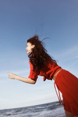 Neşeli Dans: Gülümseyen bir kadın Yazın Güneşli Sahilde Özgürlük ve Mutluluğu Kucaklıyor