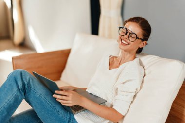 Modern İçişleri Bakanlığı 'nda bir koltukta otururken dizüstü bilgisayarda yazan çekici genç kadın.