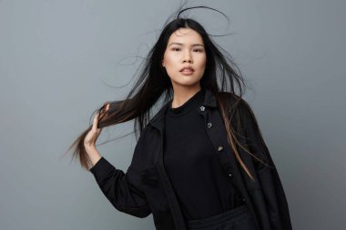 Kadın gülümsüyor. Gri, sağlıklı, kahverengi bir portre. Asyalı bir kız.