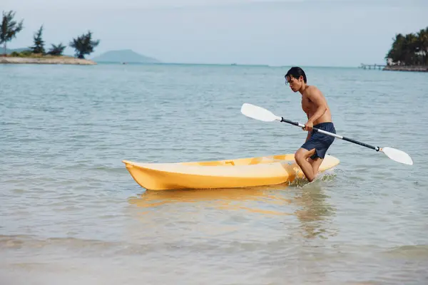 在热带冒险中乘坐独木舟的快乐亚洲人 — 图库照片