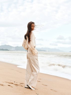 Serene Summer Beauty: Bir kumsalda tek başına oturan, sersemletici bir günbatımında okyanusa bakan genç beyaz bir kadın