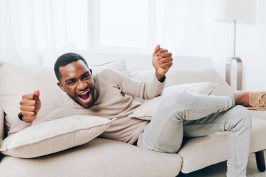 Rahatlamış Afrikalı Amerikalı Adam Evdeki Koltukta Oturuyor, Rahat Haftasonunun tadını çıkarıyor