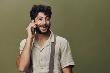 Genç adam portresi gülümsemesi seyyar, çekici, yakışıklı, iletişim kuran, neşeli, yetişkin, mutlu, telefon geçmişi olan beyaz bir adam.