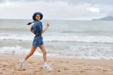 Aktif Yaz Güzelliği: Güneşli Açık Hava 'da Sahilde Egzersiz Yapan Genç Bir Bayan Atletizm