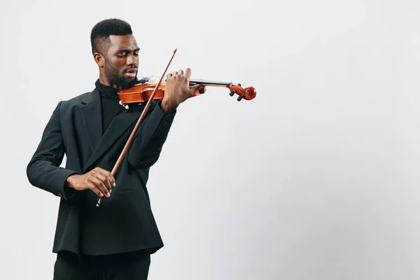 有才华的年轻非洲裔美国人 身穿时髦的黑色西服 充满热情地小提琴演奏 与白人背景隔离 — 图库照片