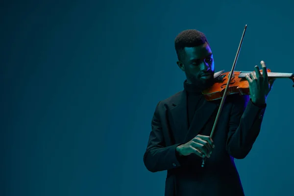 Eleganter Musiker Schwarzen Anzug Spielt Melodiöse Geige Vor Leuchtend Blauem — Stockfoto