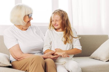 Torun kadın nesli yaşlıları seviyor kanepe son sınıf kanepede yaşam tarzı büyükanne evde mutlu aile kızı anne kız torun evde yaşlı çocuk oturuyor