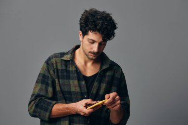 Erkek portresi kendine güveni olan, kendine güvenen, hayat tarzı gri adam, stüdyo mavi gömlek arka plan, güzel yüz ifadesi, moda saçı, teknolojik görünümlü yakışıklı adam.