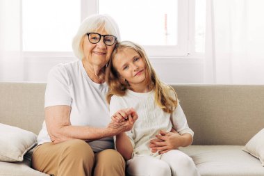 Çocuk kadın mutlu ev kadınlarını sever. Anne torununa sarılır. Kanepe kızı.