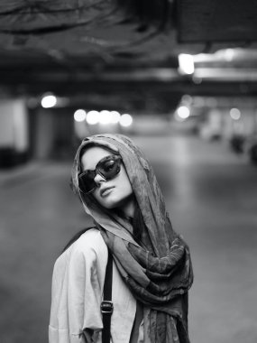 Beyaz kadın şehir sokaklarında şık poz veriyor, şık bir sonbahar ceketi ve şık bir şapka giyiyor, güzel ve kendinden emin görünüyor ve muhteşem bir arka plana karşı.