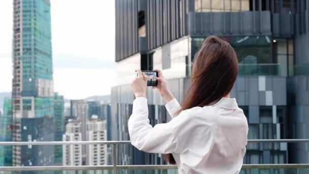 Uma Mulher Filmando Vídeo Seu Telefone Telhado Edifício Contra Pano — Vídeo de Stock