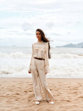 Yaz Güzeli: Sahilde Genç Bir Kadın, Güneşin Sıcaklığını ve Okyanusun Huzurunu Kucaklıyor