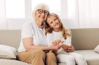 Yaşam tarzı kadın kanepe son sınıf kucaklama kanepe aile kız büyükanne çocuk ev anne torun yaşlı mutlu yaşlı oturuyor