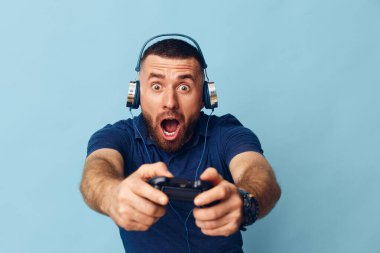 Mutlu adam portresi konsolu arka planda video kulaklık çalıyor ifade sanatçısı genç yetişkin yaşam tarzı eğlence oyunu adamı eğlence oyuncusunun oyun çubuğu teknolojisini kontrol ediyor