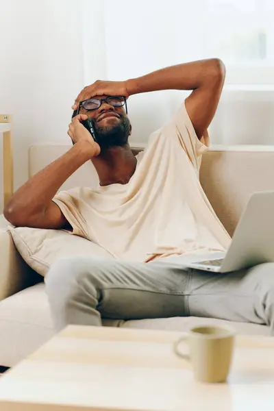 Sorrindo Afro Americano Homem Trabalhando Laptop Conversando Telefone Aconchegante Home — Fotografia de Stock