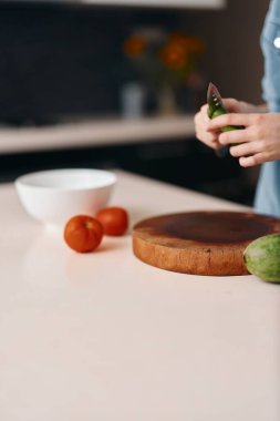 Taze ve Sağlıklı: Mutfakta Kadın, Ahşap Tahta Üzerinde Neşeli İfade ve Canlı Arkaplan ile Lezzetli Meyve Kesiyor