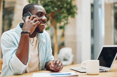 İş adamı telefon mutlu yetişkin masası gülümseme profesyonel oturan bilgisayar teknolojisi yaşam tarzı ofis erkek iletişim mobil iş konuşan genç kişi siyah