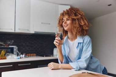 Güzel Afrikalı Amerikalı Kadın Evindeki Mutfağında Bir bardak su tutuyor Sağlıklı Yaşam Tarzı Konsepti