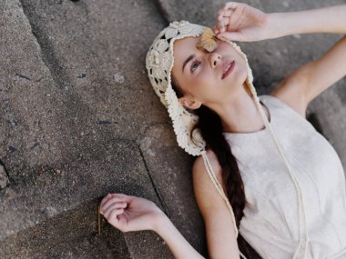 Kaygısız Yaz: Genç Çekici Kadın Süslü Beyaz Elbiseyle Keyifli Zaman Geçiriyor, Mavi Gökyüzü Arkaplanı ile Yeşil Çimlerde Uzanıyor