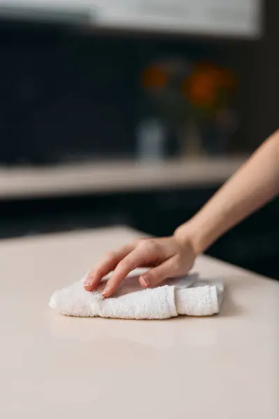 Womans Hand Wiping White Kitchen Table, Removing Dirt and Wet Dough with Cloth, Creating Fresh Homemade Bread