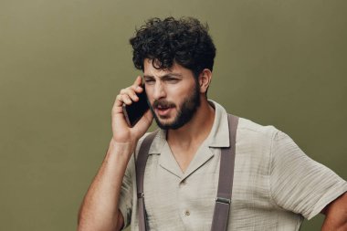 Kucağında beyaz, genç, rahat görünümlü bir iş adamı. Yüzünde portre var. Mobil, izole bir gülümseme.