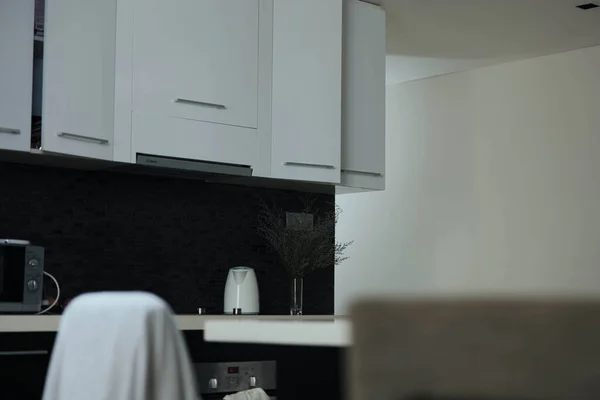 Einfarbige Kücheneinrichtung Mit Eleganten Weißen Schränken Und Einer Kontrastierenden Schwarzen — Stockfoto