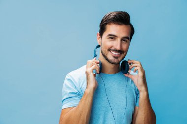 Adam arka planda şarkı söylüyor konuşan adam müzik mutlu eğlenceli portre uzay stüdyosu mavi kulaklığı kes İnternet tişört duygusunun tadını çıkar