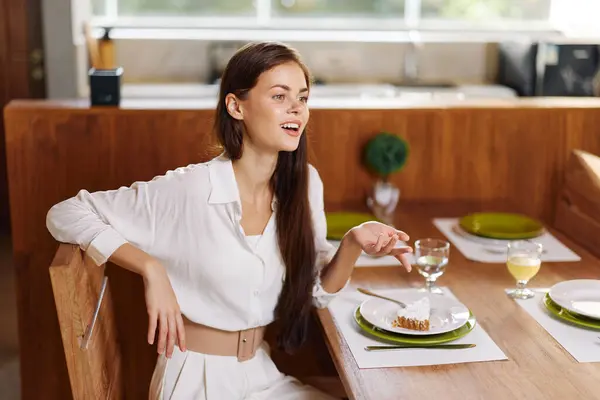 Romantic Dinner Date at Home Woman Smiling with Joy while Enjoying a Delicious Homemade Meal at a Beautifully Set Dining Table The Trendy and Stylish Dining Room is Adorned with festive Christmas