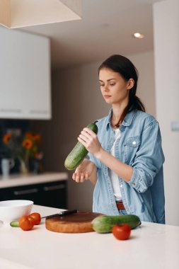 Mutfakta sağlıklı vejetaryen salatası yapan taze, beyaz bir kadın.